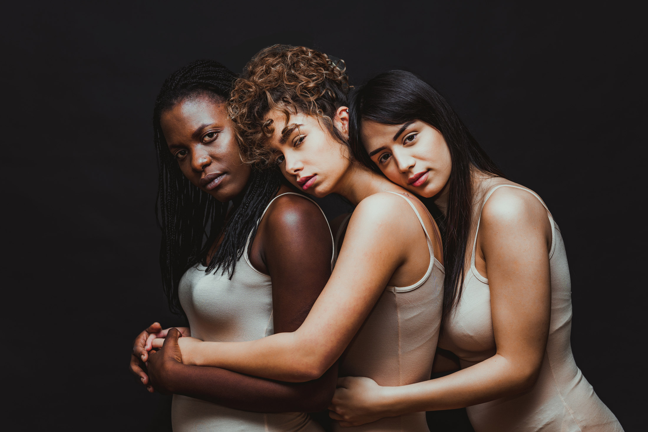 Three women embracing and posing for a photo